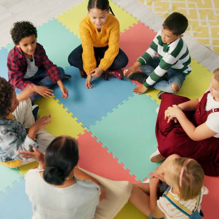 Children sitting in circle on colorful foam mat