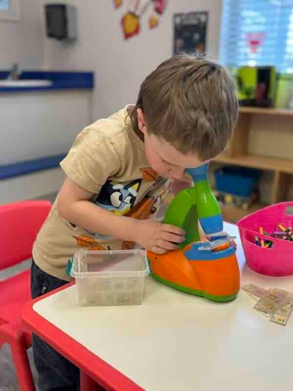 Young child playing with toy cash register indoors