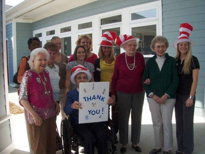 Group with red striped hats holding thank you sign