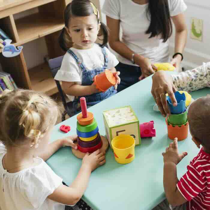 Toddlers playing with stacking toys at table